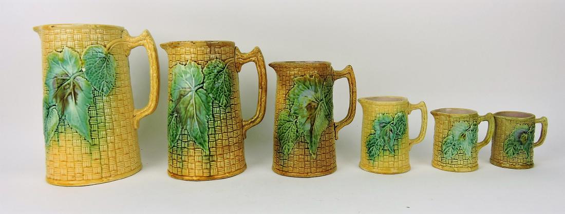 Majolica lot of 6 graduated begonia: and basket pitchers, 3 1/4" to 9 1/2", various condition