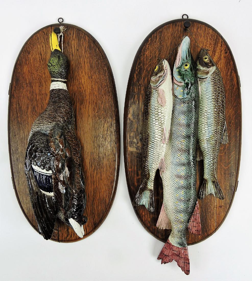 Hugo Lonitz monumental pair of: majolica wall plaques, one with mallard duck, the other with three fish each mounted on original oak plaques; duck 24", fish 26 1/2", wood plaques 26" x 13 1/2", professional repair to duck's wing tip