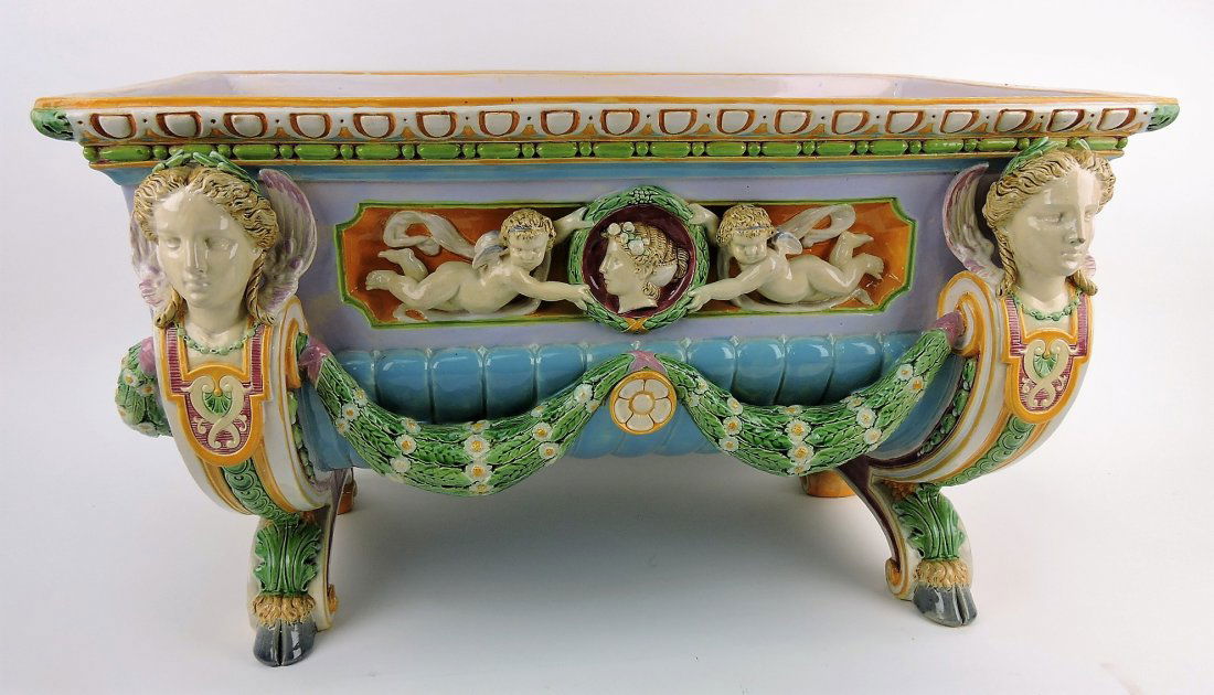 Minton majolica large rectangular: cistern in the form of large trough with winged ladies on corners connected with flower and leaf garlands, lion's head handles and hooved feet, panels on each side with winged cherubs in high relief h