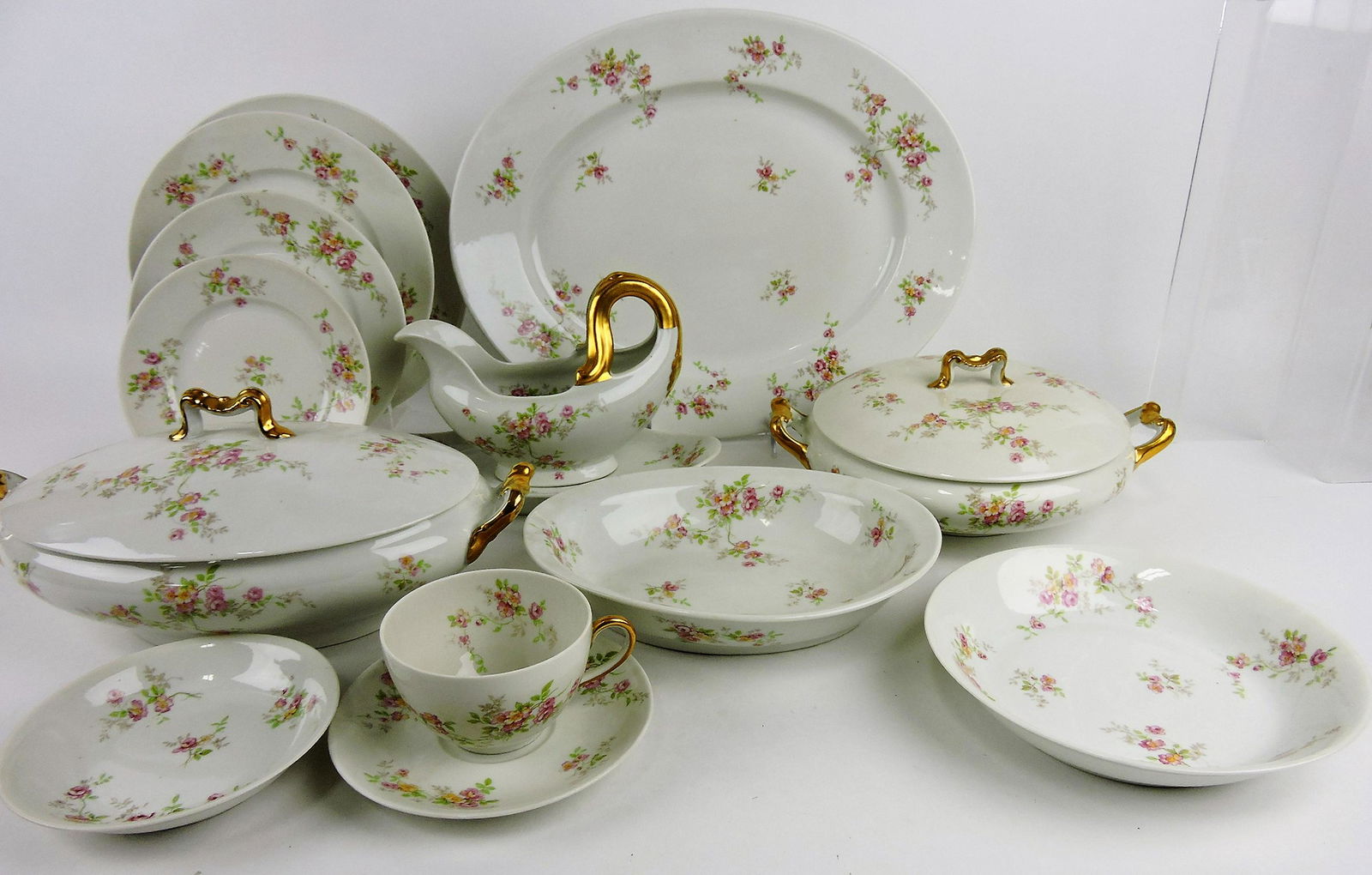 French Limoges set of china, 86 pieces;: oval and round tureens, gravy boat & stand, 15" & 11" platters, 9" oval bowl, 11 - 9 1/2", 12 - 8 1/2", 12 - 7 1/2", 10 - 6 1/4" plates, 10 - 7 1/2" & 12 - 5 1/2" bowls, 6 cups, 6 saucers
