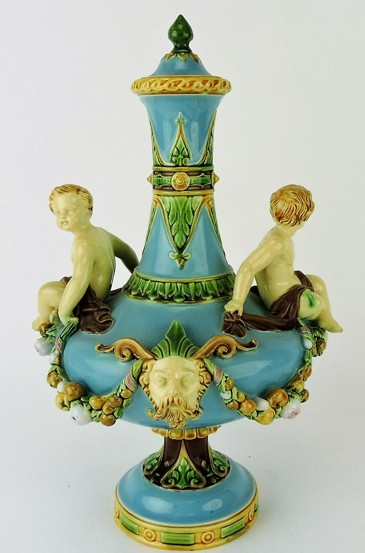 Minton majolica turquoise covered: urn with putti on each side separated by mythological masks, lid restored, 13 1/2"