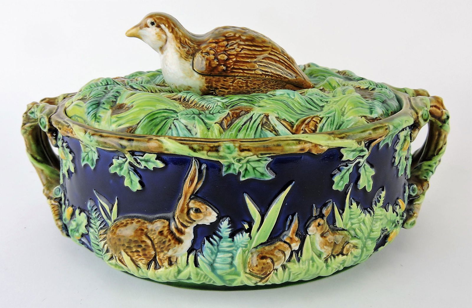 George Jones majolica cobalt: game dish with quail on cover, base with rabbits, oak leaves, and acorns in high relief, 11'w, 6"h