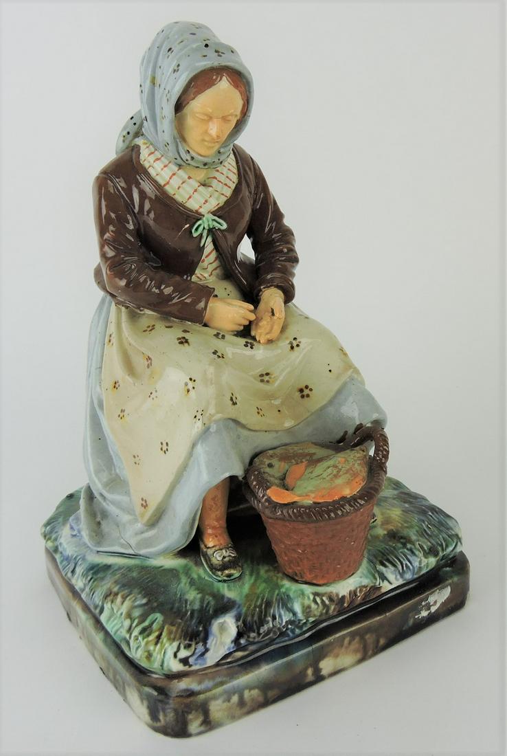 Majolica figure of lady with basket: of fish, 9 1/2"