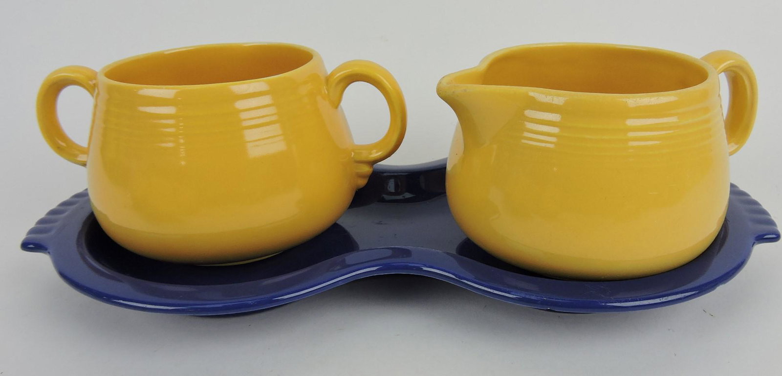 Fiesta cream/sugar set with cobalt figure 8: tray, yellow creamer & sugar, nicks to tray