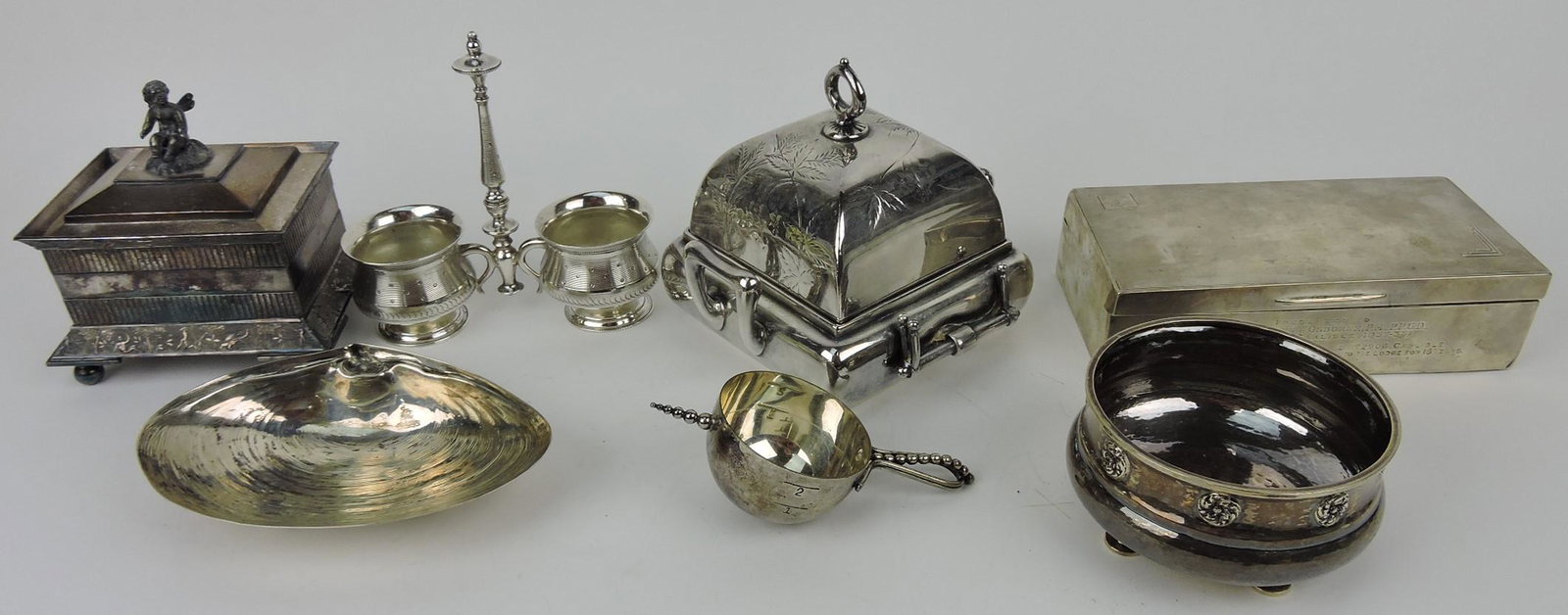 Lot of silver items: cherub covered box,: double salt, butter dish, cigarette humidor, sterling clam shell, jigger shot roll, and footed bowl