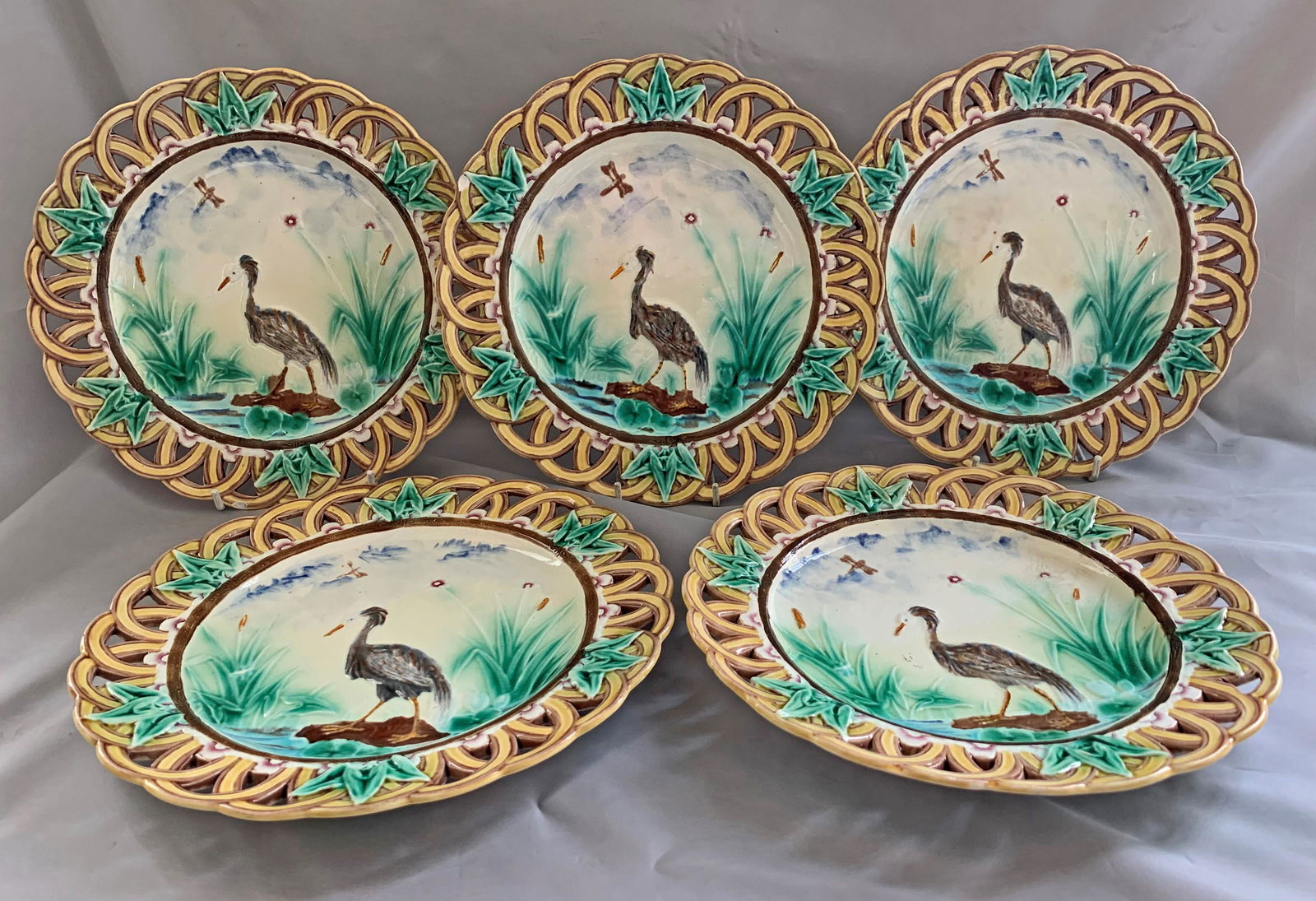 Wedgwood majolica set of 5 heron: plates designed by Theodore Deck, with standing heron, cattail, lily pad, dragonfly detail, and reticulated border, 9 1/4"