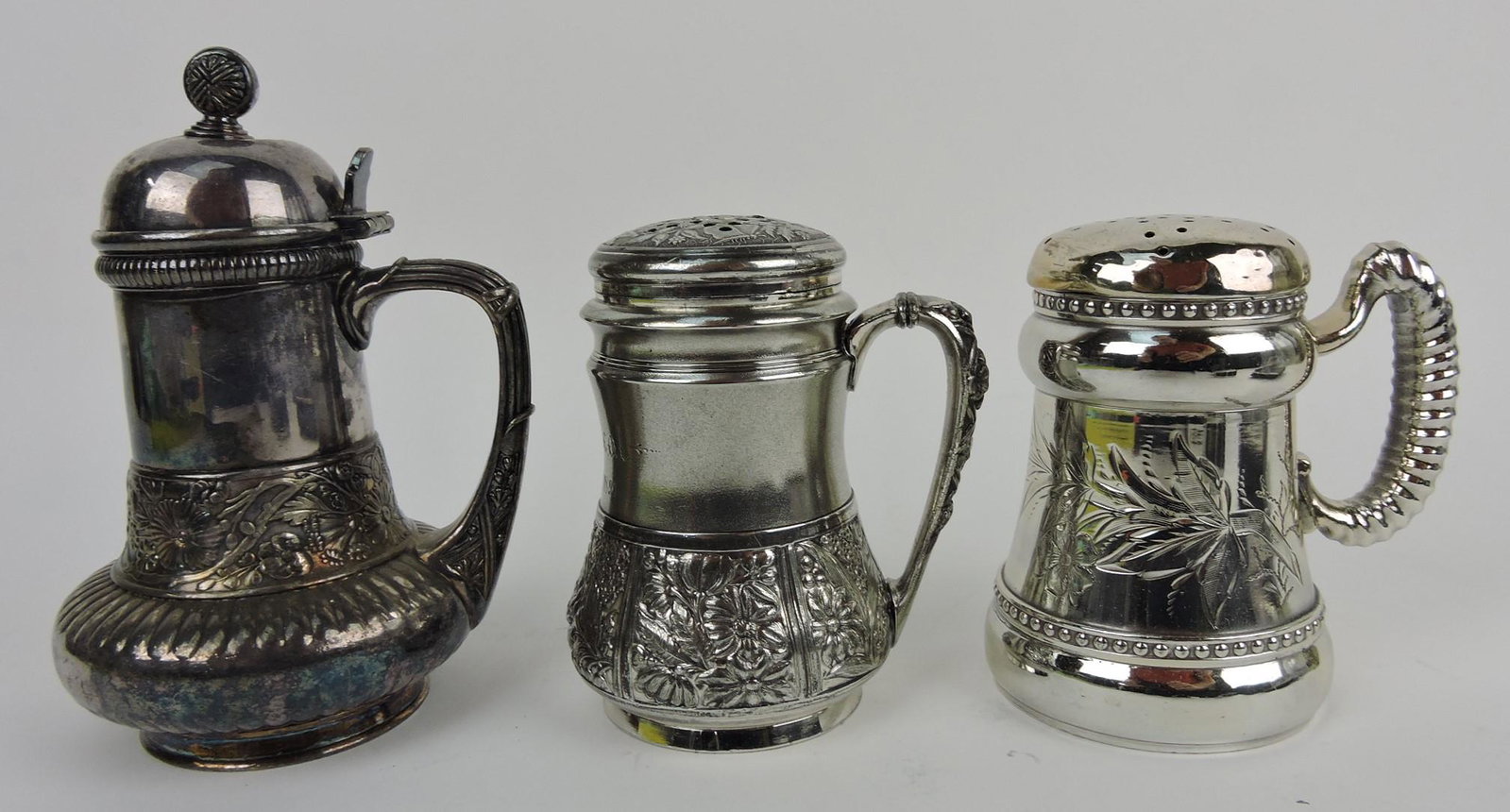 Lot of 3 silverplate items: Simpson Hall: Miller ribbed and floral embossed syrup pitcher, Pairpoint muffineer, Philadelphia muffineer, embossed and engraved