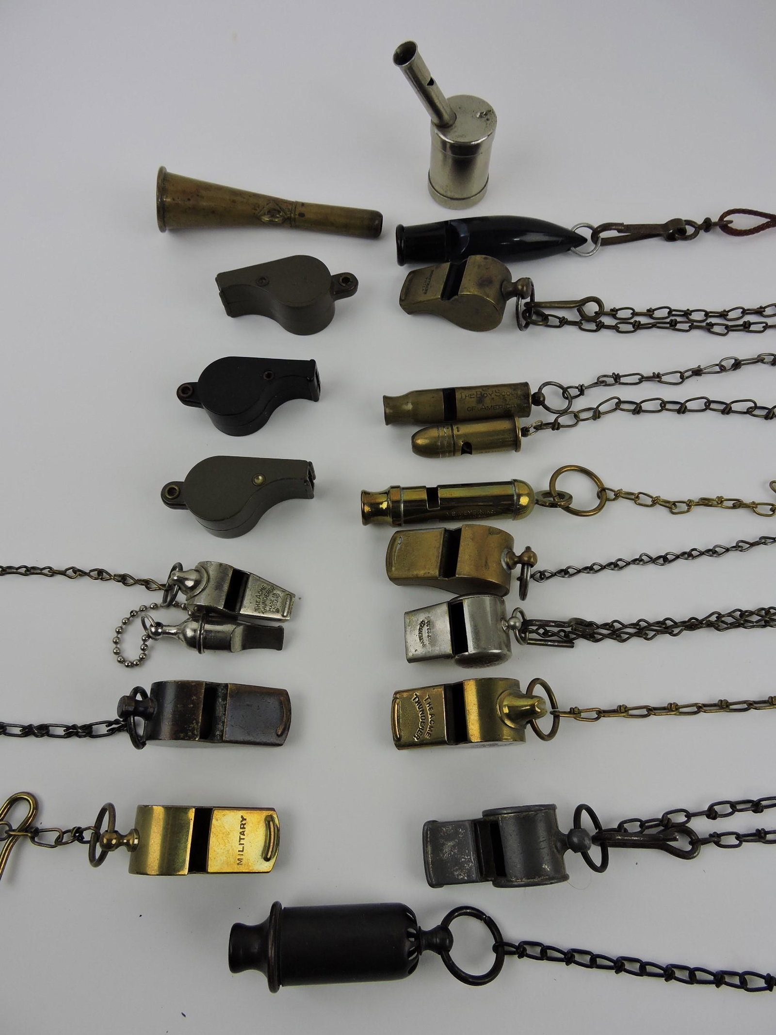 Lot of 19 whistles, mostly brass -: The Acme Thunderer, Military, Boy Scout, Echo, N.S. Meyer, Horstmann, many with chains