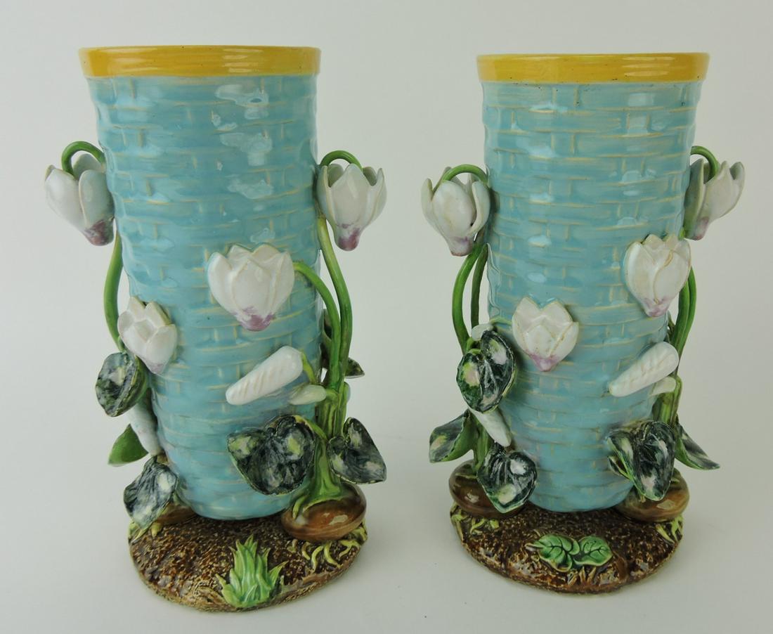 George Jones majolica pair of cyclamen: vases, each modeled as a turquoise woven upright basket with applied cyclamen plants emerging from three bulb feet supported on earthy ground base, 8", Ann & Robert Fromer Collection
