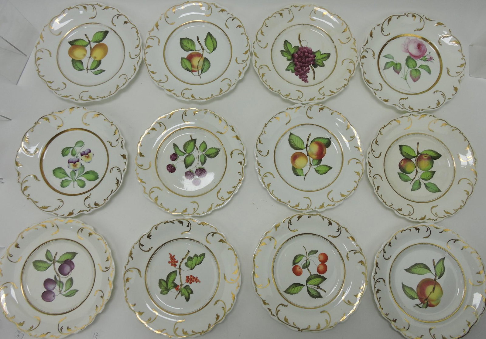 Staffordshire set of 12 - 9" hand painted: plates, each with different fruit or floral motif, hairline to one