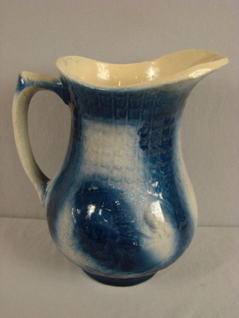 Blue and white stoneware pitcher with rose and fis: Blue and white stoneware pitcher with rose and fish scale design, 10"