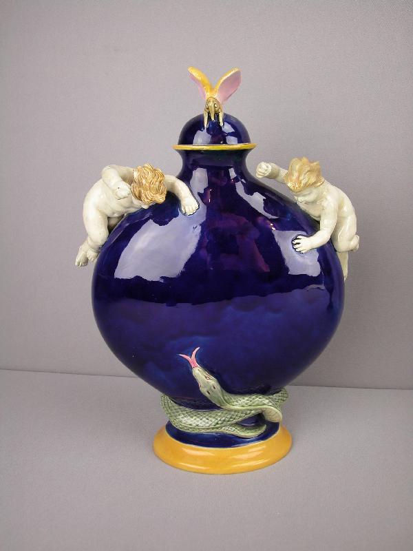 T.C. BROWN WESTHEAD MOORE & CO cobalt majolica: T.C. BROWN WESTHEAD MOORE & CO cobalt majolica moon vase with two putti handles and snake wrapped around base with butterfly on cover, rim repair to top of base and butterfly wings, 12"h, 9"w