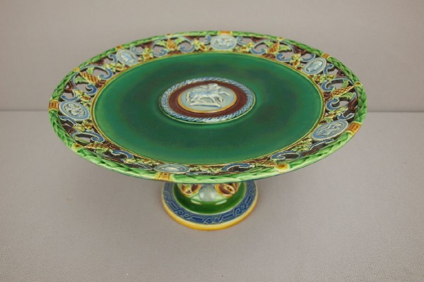 MINTON majolica rare form tazza with snake coil: MINTON majolica rare form tazza with snake coiled around base supporting a reticulated tazza with pinecones and scenic panels in reticulation and mythological figure in center, 9 1/2"d, 5"h