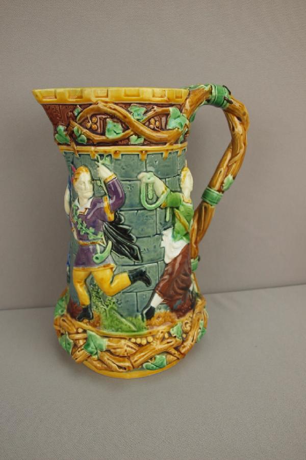 MINTON majolica tower jug with figures in high: MINTON majolica tower jug with figures in high relief, early staple repair to handle, 9 1/2", shape no. 1231