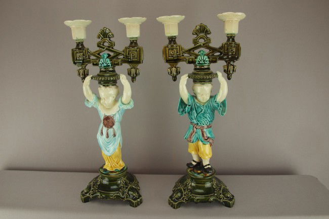 European majolica pair of figural candelabras each: European majolica pair of figural candelabras each with a cherub support, professional repair to candle holder of both, 16"h, attributed to Choisey le Roi.