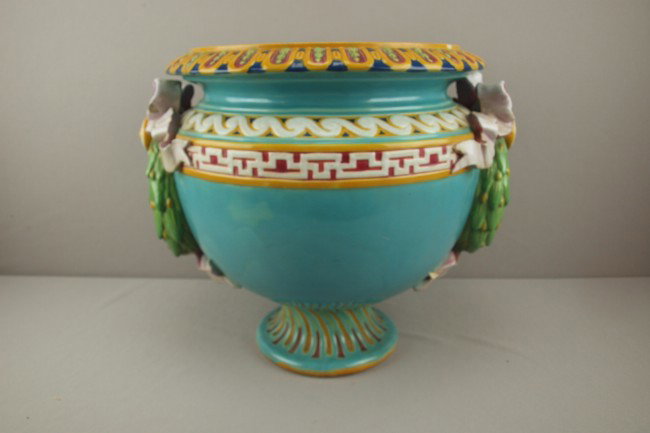 MINTON majolica turquoise pedestal jardiniere with: MINTON majolica turquoise pedestal jardiniere with ring handles with pink ribbons and bows, rim chip, chip to ribbon handle, chip to bottom of interior, 15"h, 18"w