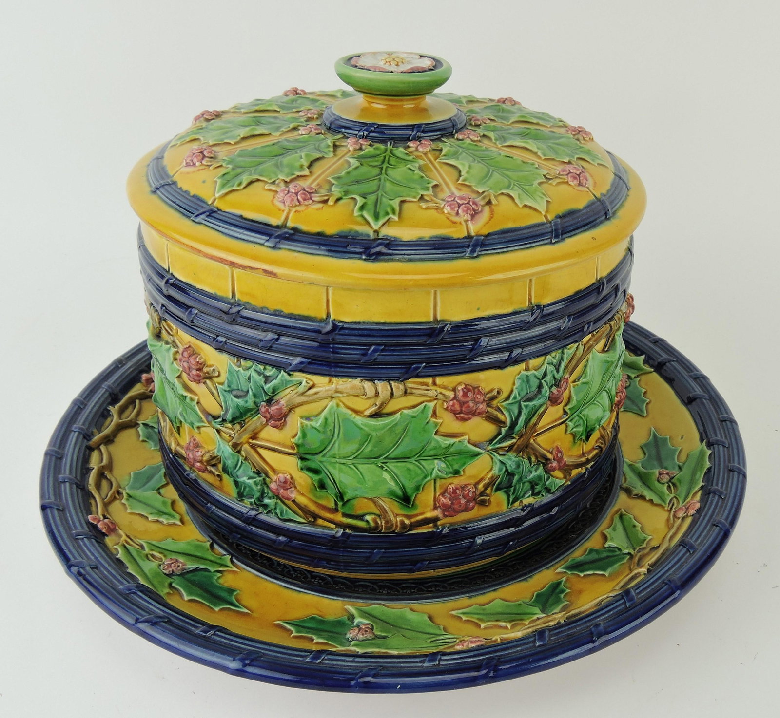 Rare Minton majolica Christmas: pudding tureen, bright yellow barrel with cobalt bands, holly, and berries, 12 1/2"d, 8"h; Betsy & Rick Porter Collection