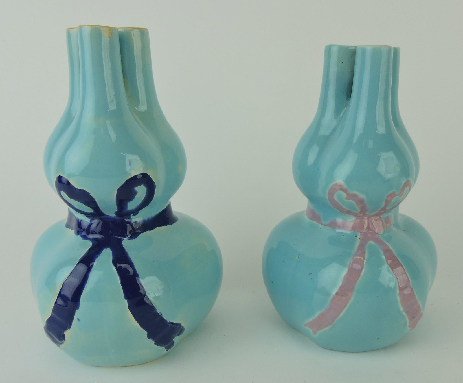 Minton majolica pair of sack triple: hole posey vases, one tied with cobalt ribbon, the other with pink, 6 1/2"
