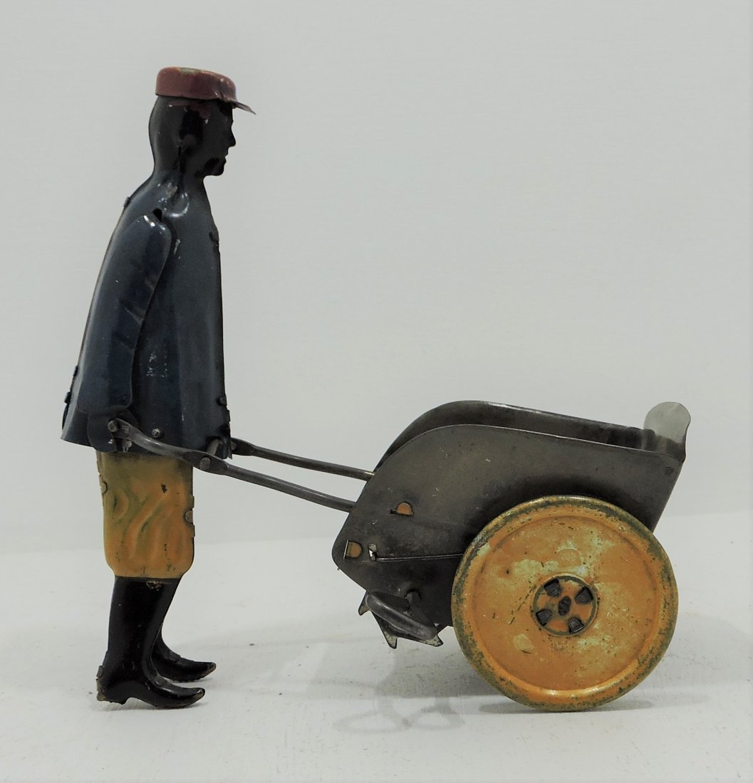 Black Americana tin litho man with cart wind: up toy, 6", works
