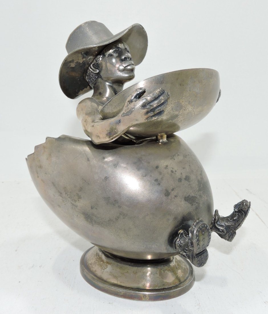 Black Americana rare Wilcox silverplate match: striker, ashtray, and cigar holder with man in an egg (cigar holder) wearing a hat (match holder/striker) holding a tray (ashtray), 7 1/2", no. 1780