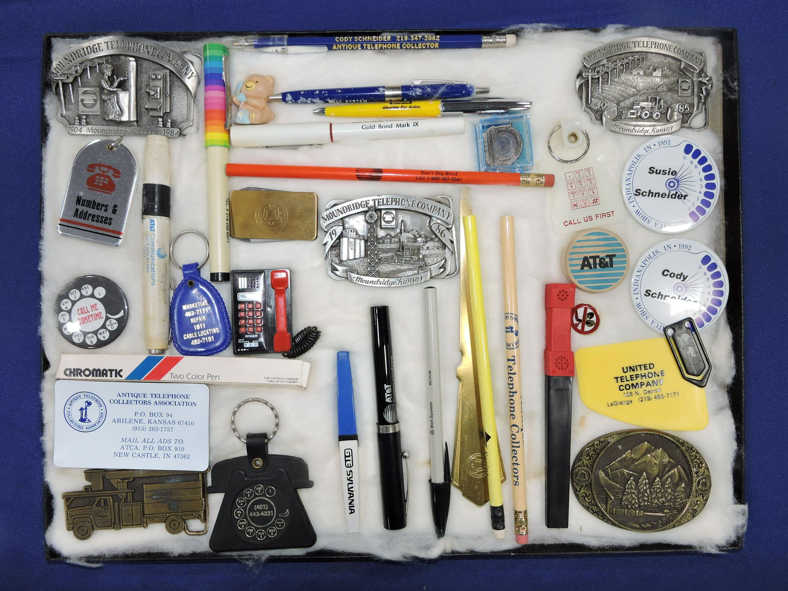 Lot of telephone related belt buckles,: keychains, pens, and pencils