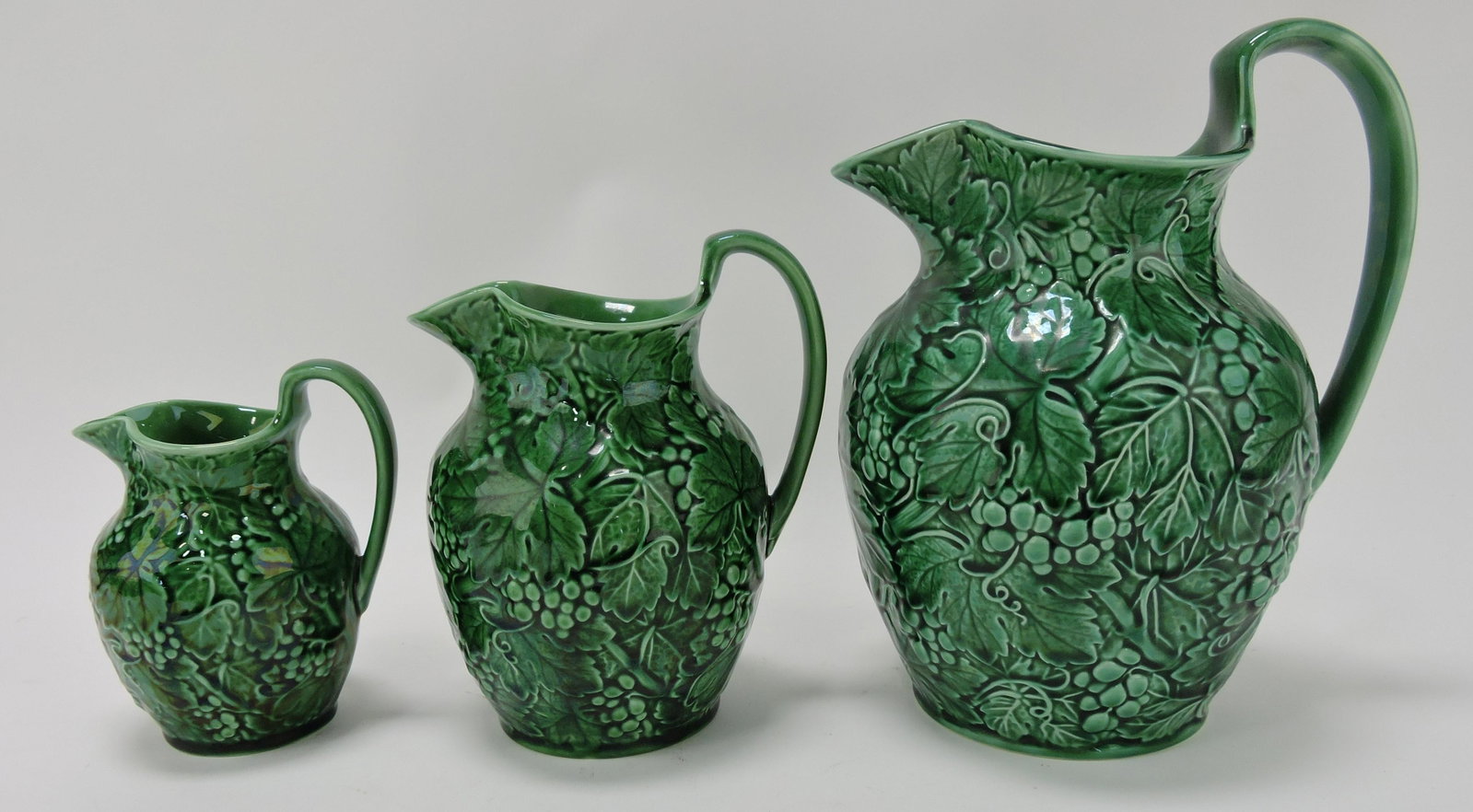 Wedgwood dark green majolica set of: 3 graduated grape pitchers, 5 to 9"