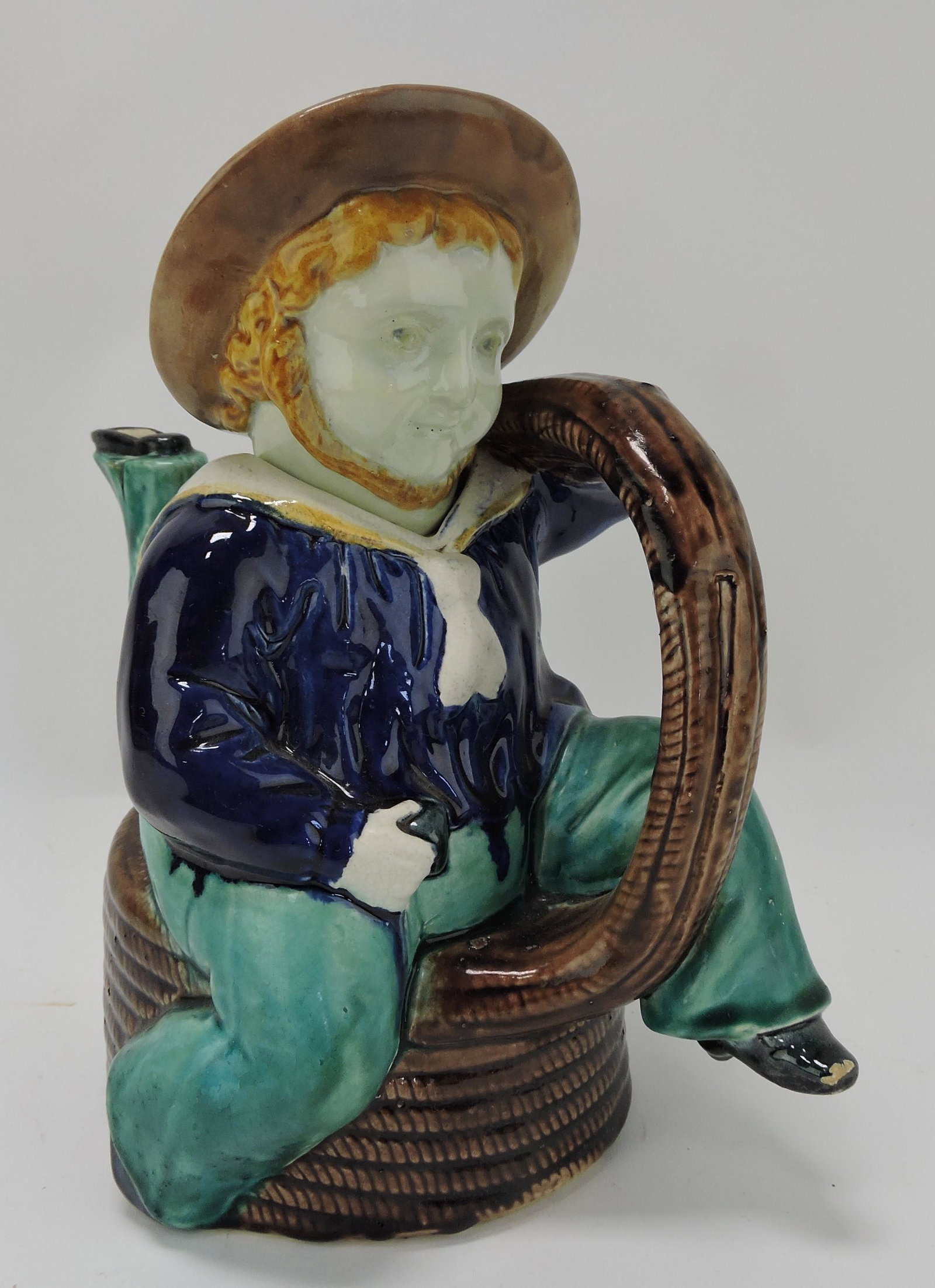 Majolica Isle of Man three legged sailor: atop coil of rope figural teapot, hat repair, 10"
