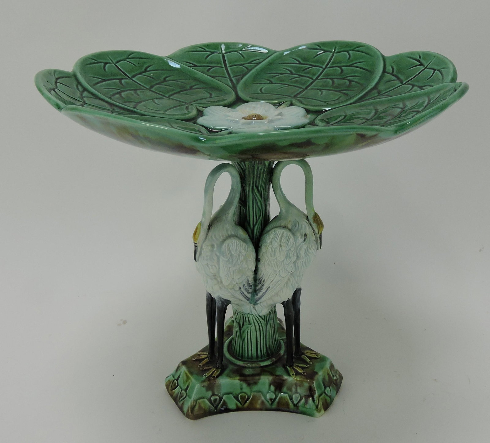 Majolica pond lily tall compote with three: white storks on base, 10"d, 9 1/2"h, minor hairline