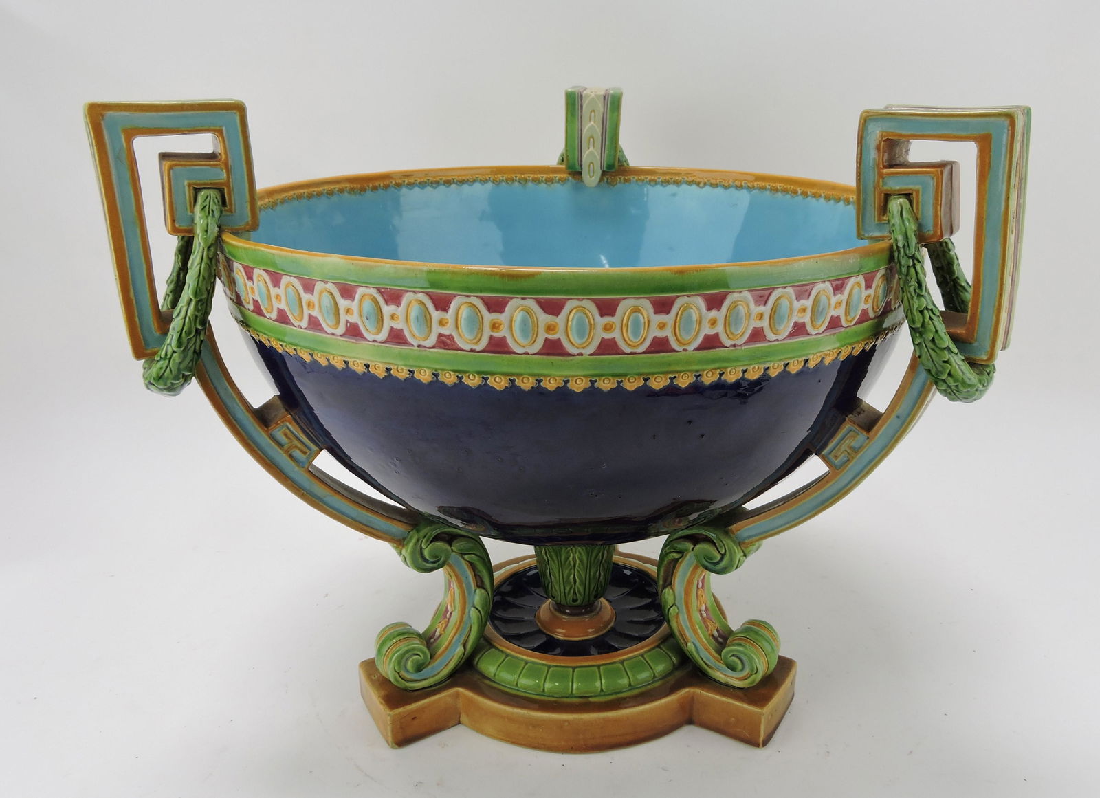 Minton majolica cobalt bowl with three: Greek bay molded handles with laurel leaves supported by tri-footed base, shape no. 1153, 13 1/2"h, 16"w, professional repair to one handle
