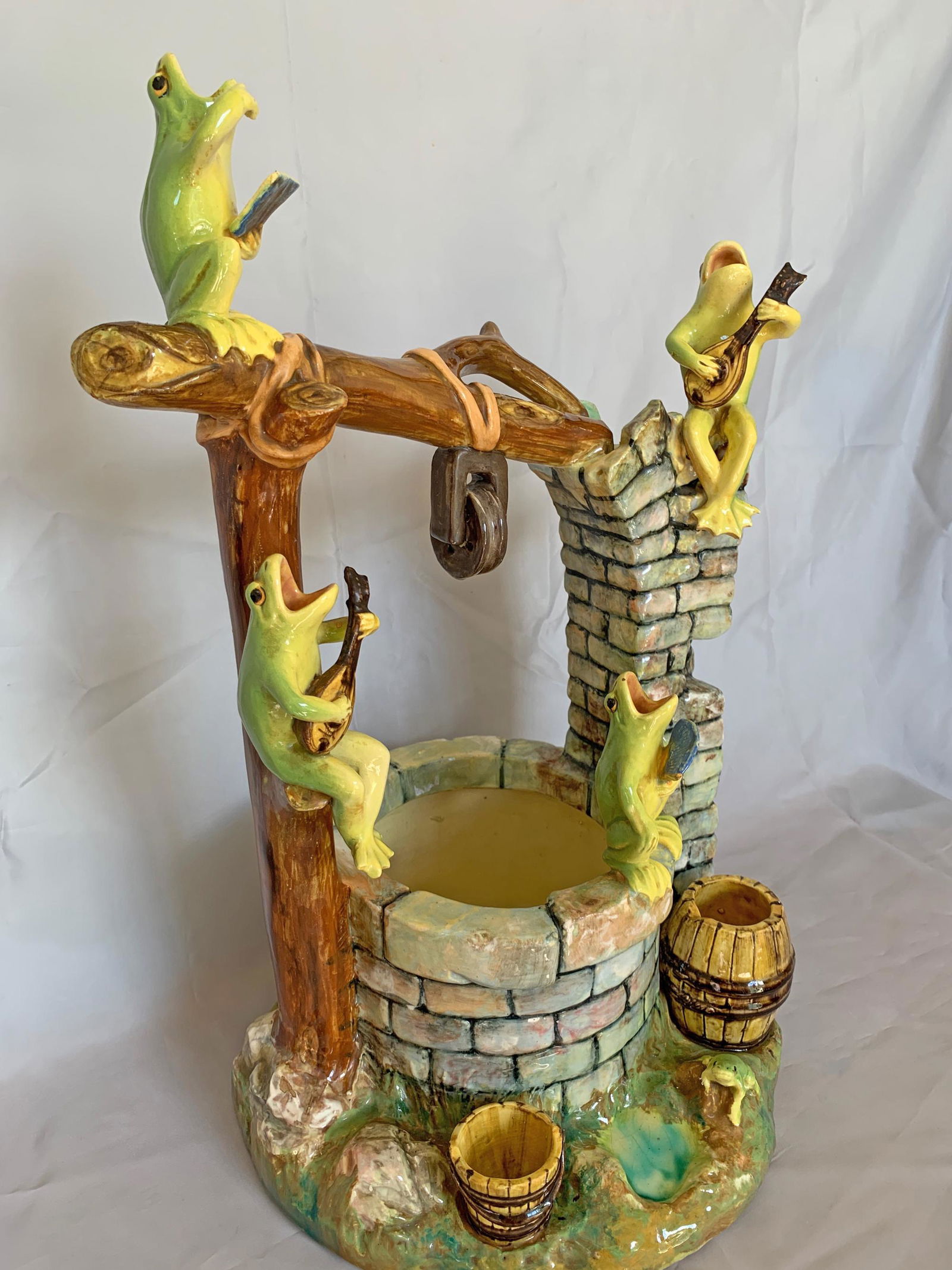 A large and whimsical Jerome Massier: majolica frogs wishing well modeled with five green singing frogs, two playing the guitar, one holding sheet music, the other a fan, and a young frog sitting at the base; great color, detail, and cond