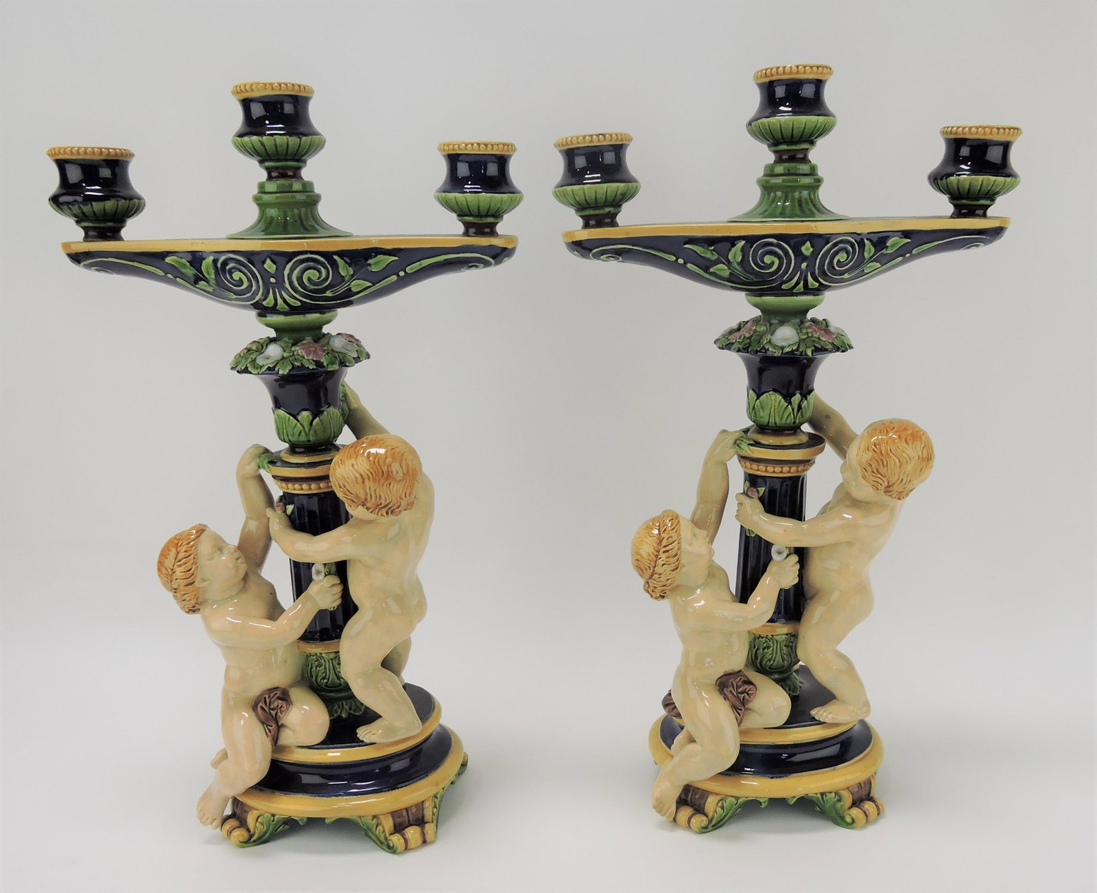 Minton majolica pair of three light: candelabras with pair of putti around column, 16 1/2"h, 9 1/2"w