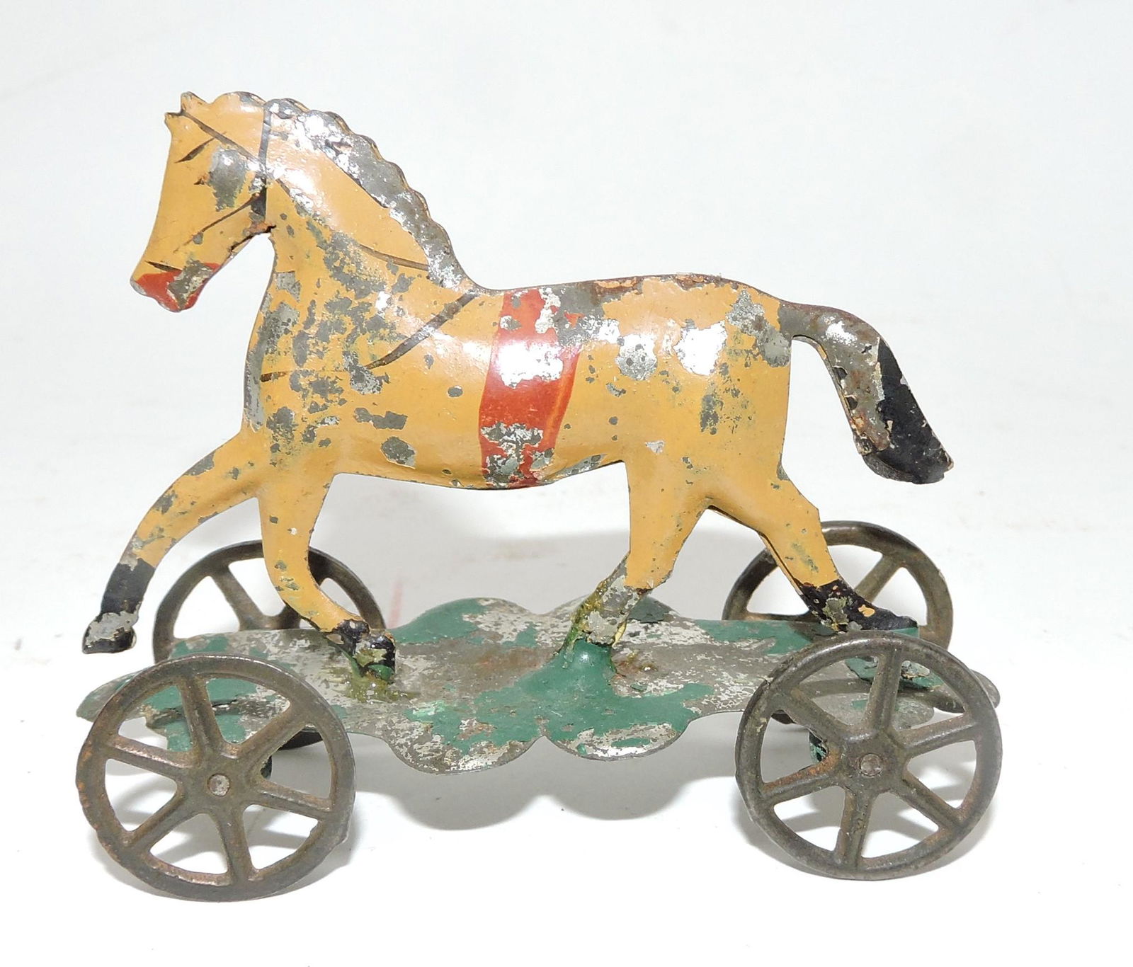 1800's tin penny toy of horse on: wheels, some paint loss, 2 1/2"h