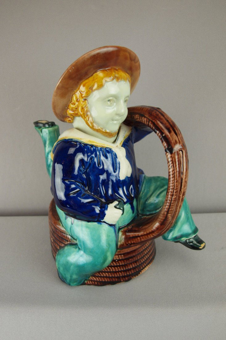 Majolica figural teapot in the form of a three le: Majolica figural teapot in the form of a three legged man on a coil of rope, 10"h, professional repair to hat rim and spout