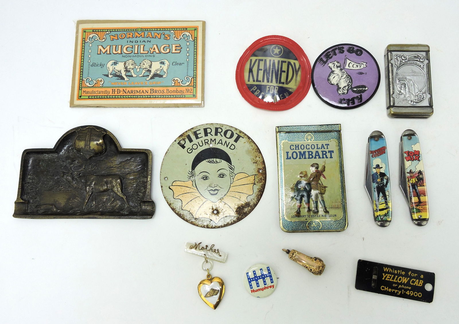 Lot of advertising and assorted items:: Norman's Indian Mucilage, JFK hologram pinback, Niagara Falls match safe, Jones Beach State Park ashtray, Pierrot Gourmand tin sign, Chocolat Lombart Paris notepad, Hopalong Cassidy and Tom Mix pocket