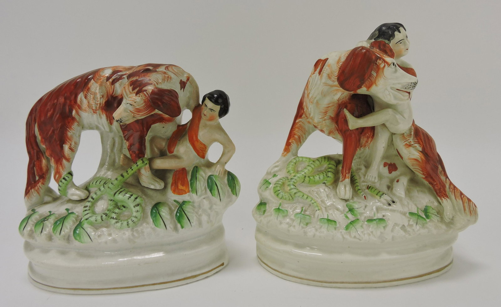 Staffordshire pair of dogs with boys: and snake on base, 7", repair to one of boy's leg and dog's snout