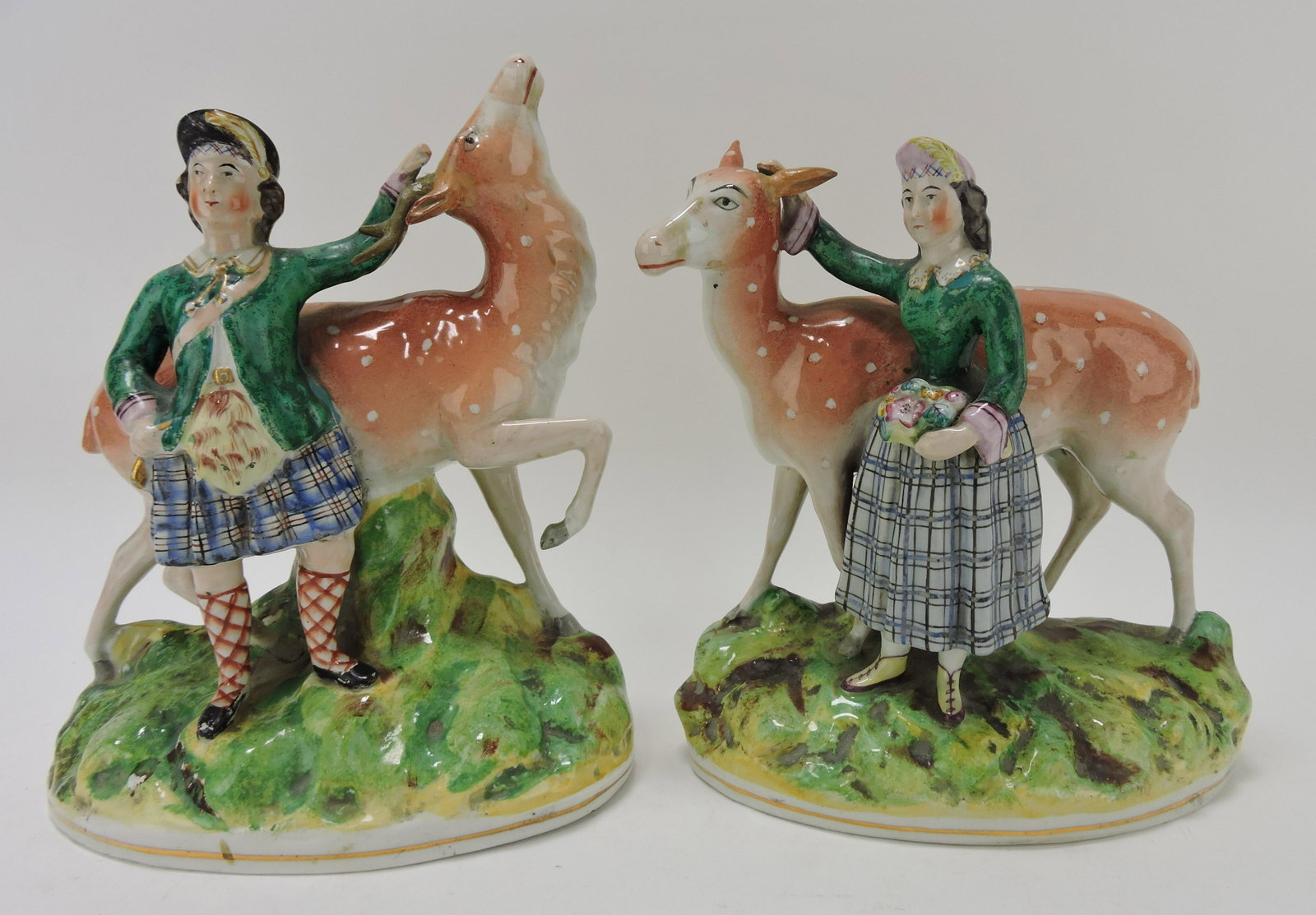 Staffordshire pair of deer figures: with boy and girl, repairs to antlers and ears, 10"