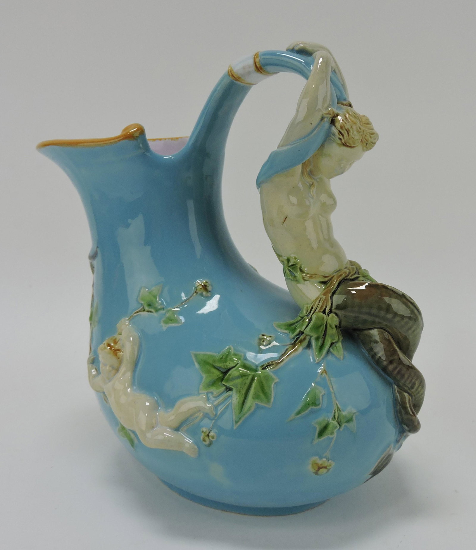 Minton majolica 'Askos' mermaid wine: jug, turquoise body, mermaid handle flanked by putti holding ivy garland, shape no. 1420, 8", ref. Dawes p72