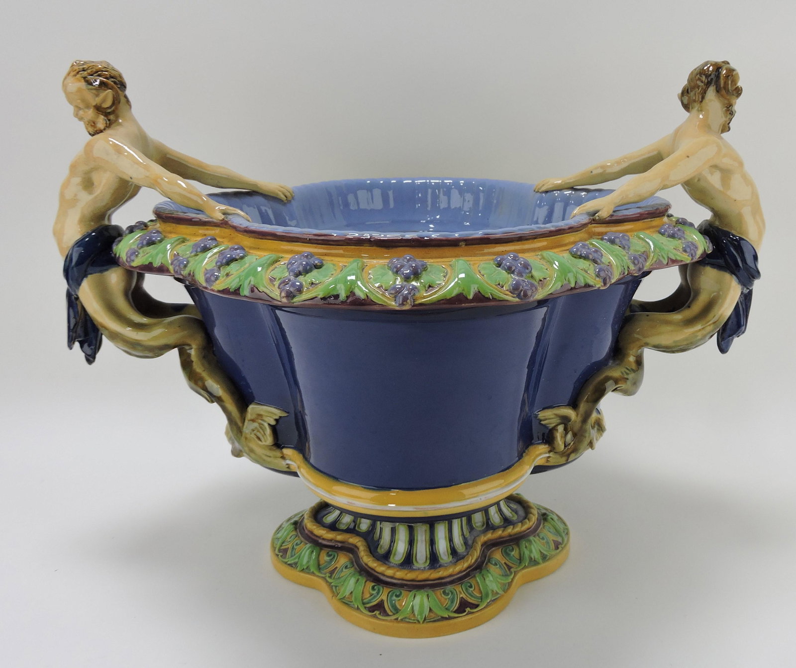 Minton majolica wine cooler/jardiniere: with mermen handles, cobalt ground with lavender rim, 15 1/2"h, 21"w; REF: Majolica Mania by Weber, Vol 1 p. 177 a similar example