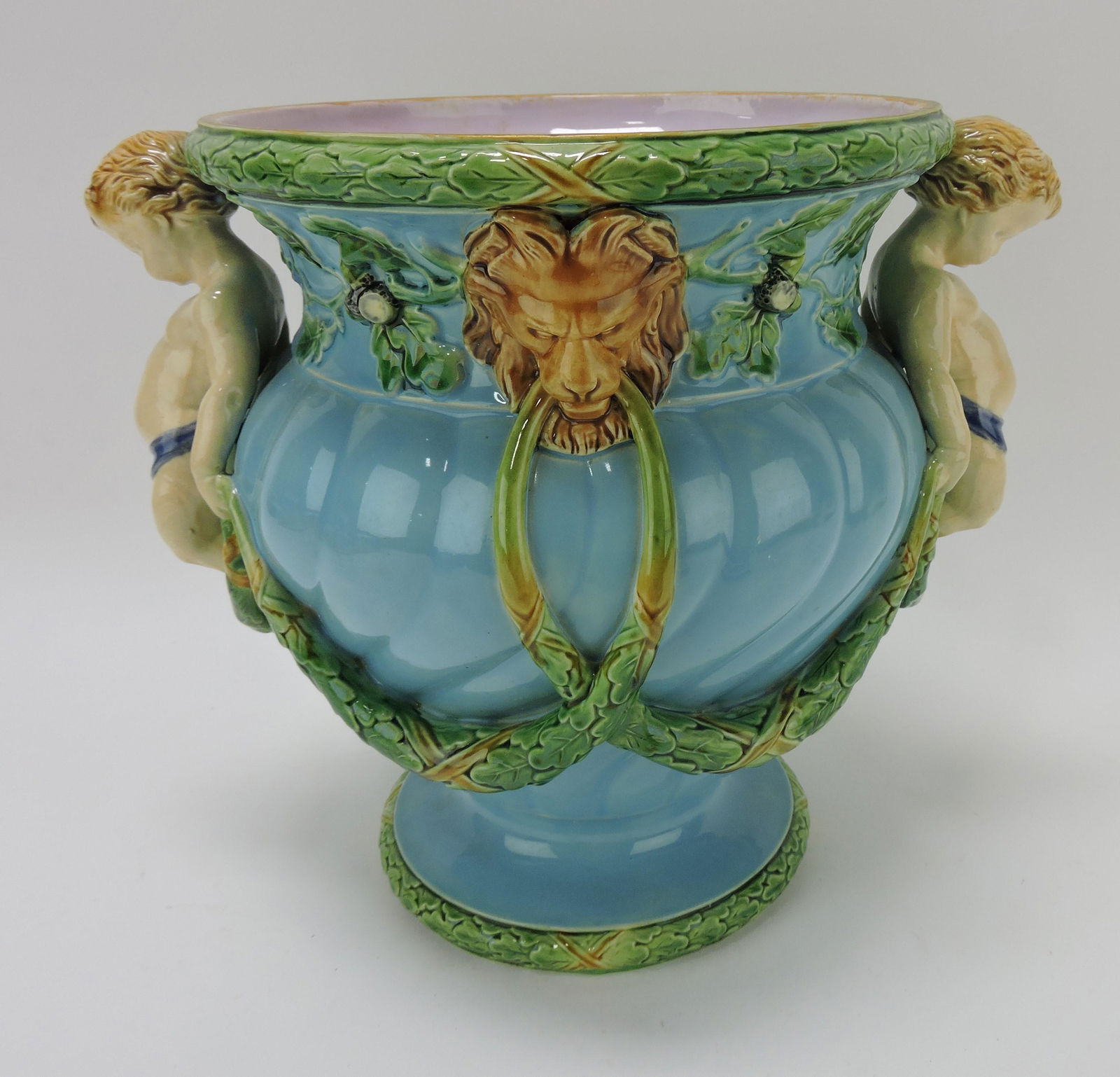 Minton majolica wine cooler with a: bulbous turquoise body with twin fawn handles and lion head masks with laurel swags, 10 1/2"h, 12"w, shape no. 1018