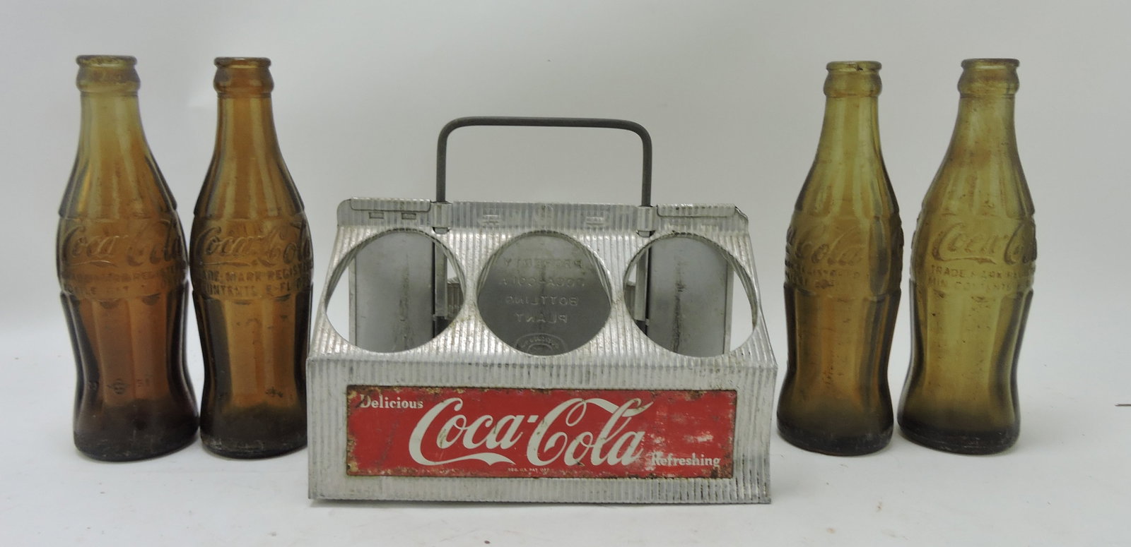Coca Cola aluminum 6 pack carrier: with 4 amber Coca Cola bottles, Fort Wayne IN, Buffalo NY, Washington IN, Live Oak FL