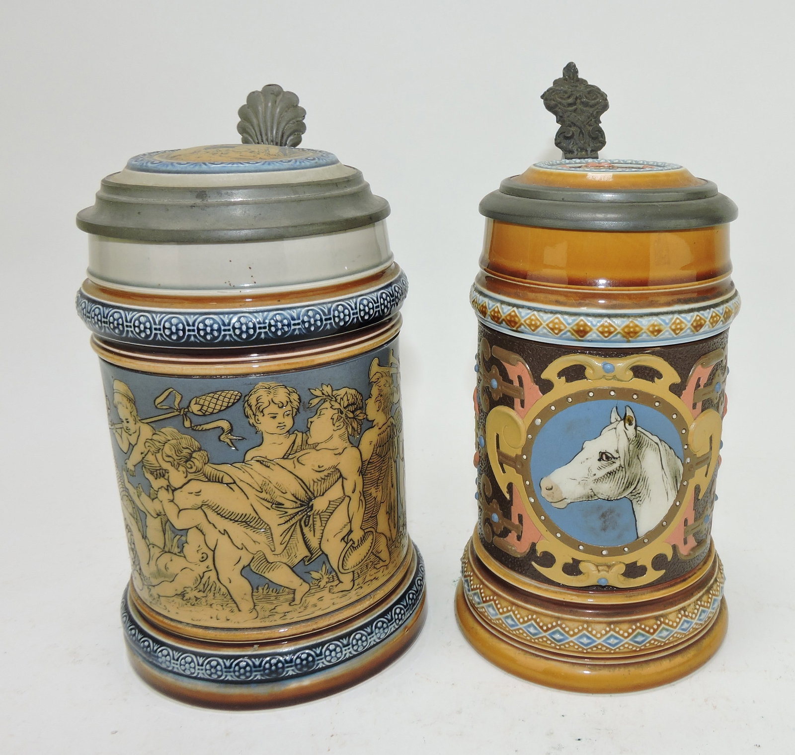 Mettlach lot of 2 steins, #2025 1/2L,: cherubs carousing AND #1454 1/2L, horse head
