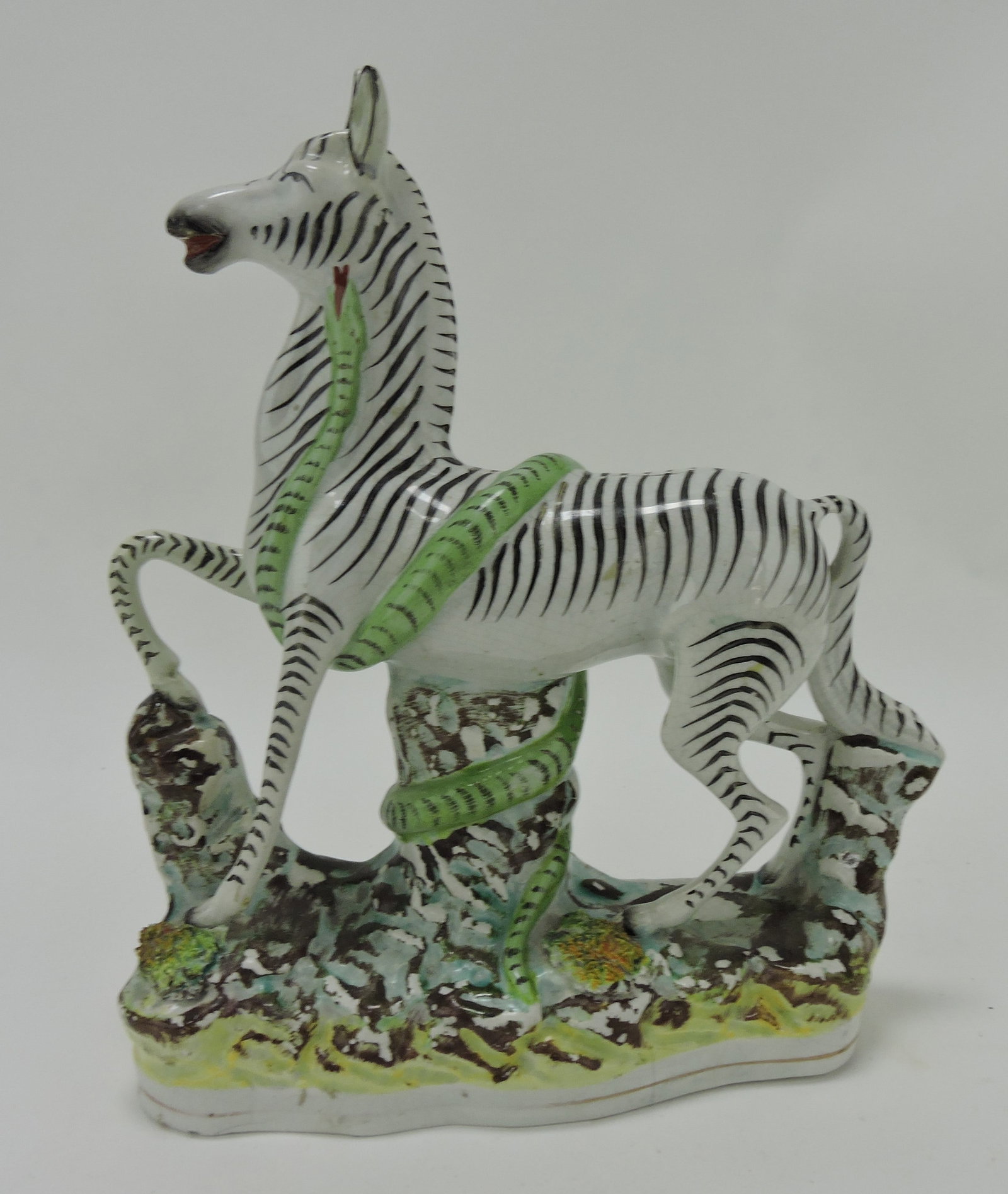 Staffordshire figure of a zebra and: serpent, repair to ears and right front leg, 10 1/4"