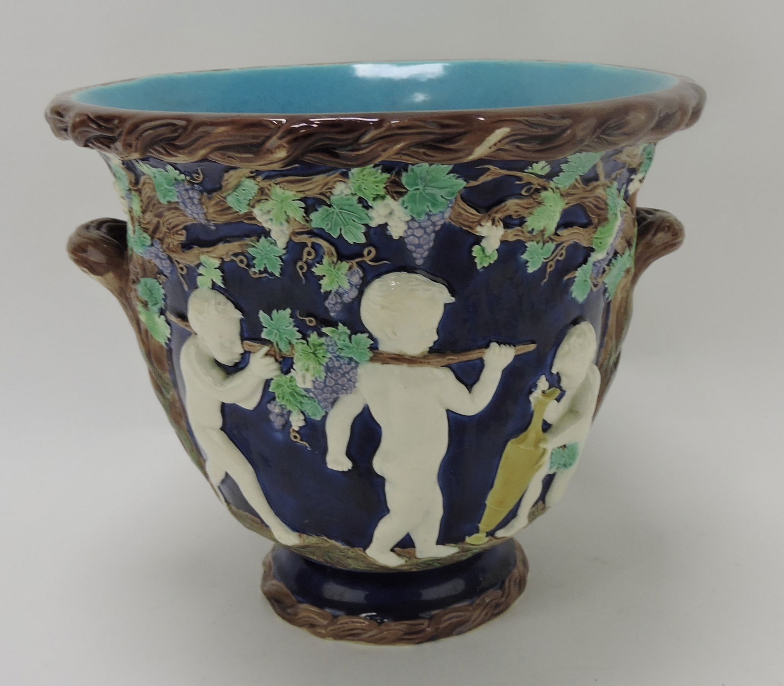 Copeland majolica cobalt wine cooler: with cherub gathering grapes on one side and drinking wine on the other, 9"h, 10"d