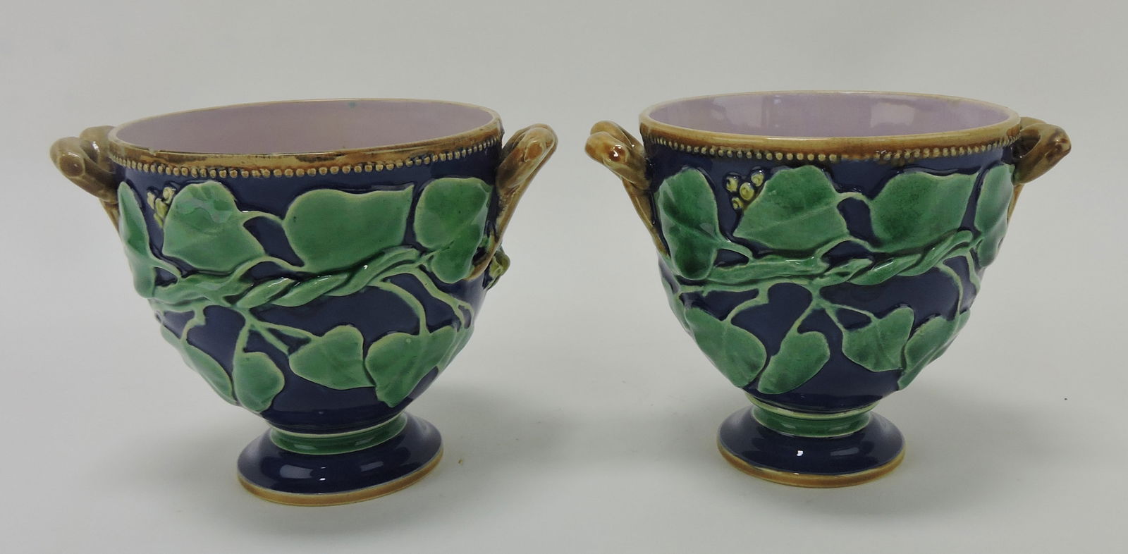 Minton majolica pair of sauce cups: with cobalt ground and ivy and berries in relief, rim nick to one, 3 3/4"