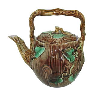 George Jones Majolica Rustic Kettle: c.1875, 7 1/2", the body modelled as tree trunk with leaves issuing from a branch handle, the spout as branch, the cover with leaves and twig handle. Catalogued and curated by Nicolaus Boston. Flower