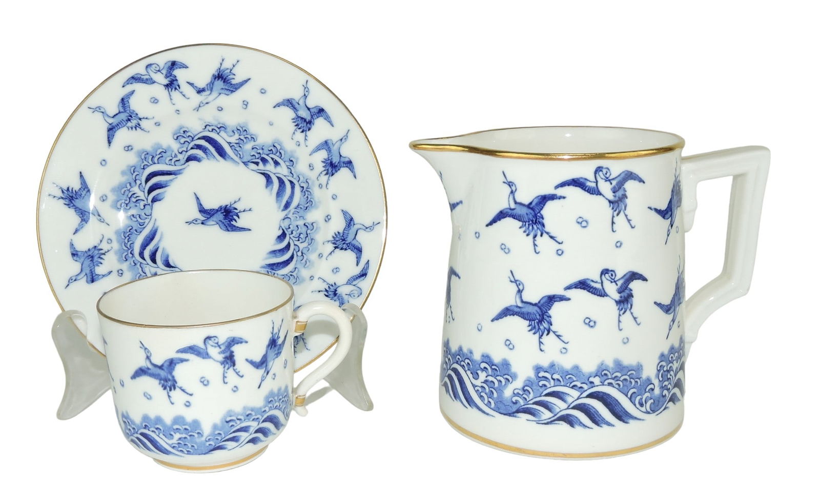 Two Pieces of Mintons Porcelain in: the ‘Japanese Crane’ Pattern, c.1875 designed by Christopher Dresser, the cup and saucer and milk jug with white grounds and blue decoration; pitcher 4 3/4", professional rim repair to cup Catalog