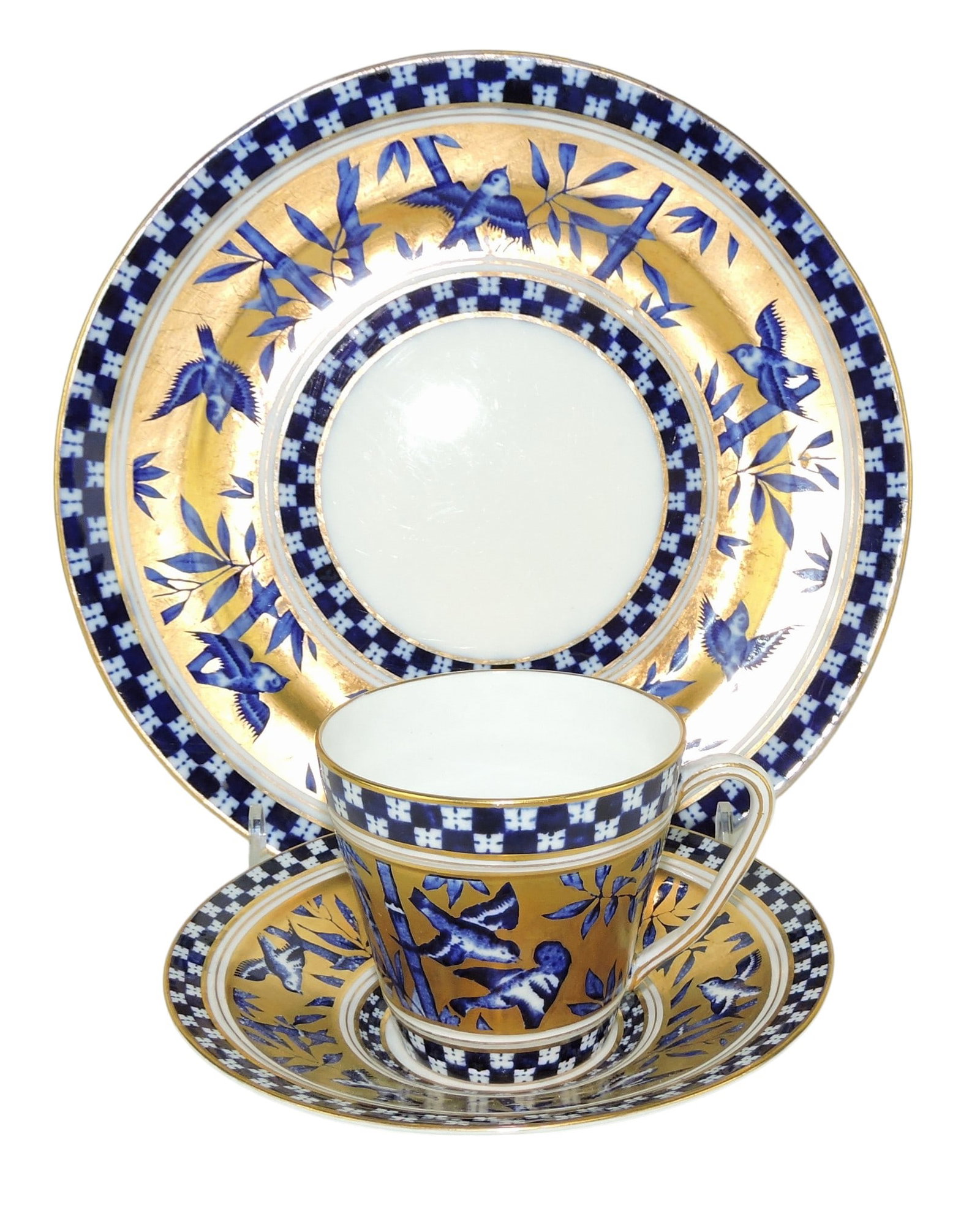 Coalport Porcelain Aesthetic Movement: Japanese Grove Trio c.1880, comprising cup, saucer and side plate, the white ground body with blue transfer against 22ct gilded background; plate 8 3/4" Catalogued and curated by Nicolaus Boston