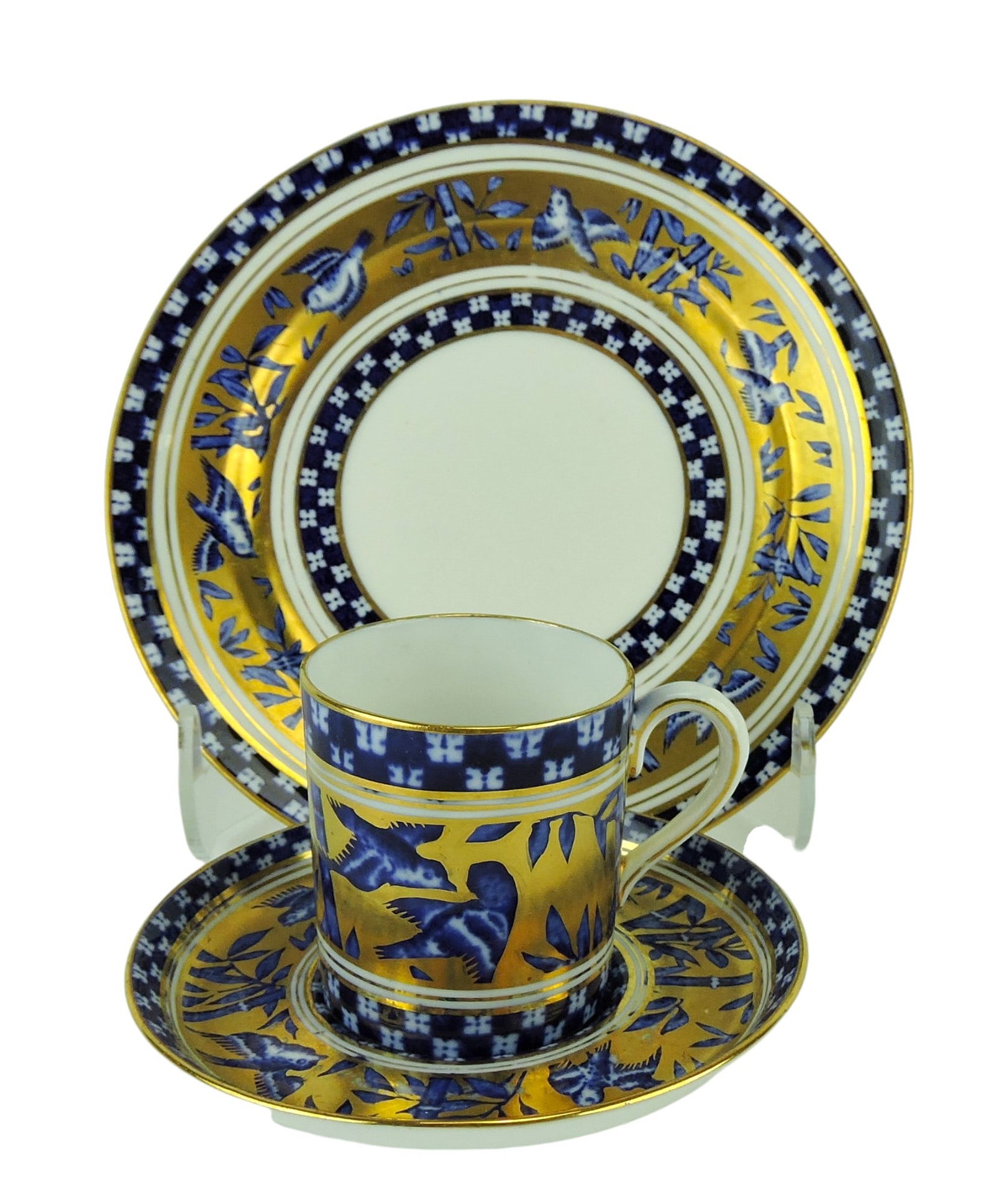 Coalport Porcelain Aesthetic Movement: Japanese Grove Trio c.1880, comprising cup, saucer and side plate, the white ground body with blue transfer against 22ct gilded background; plate 6 1/2" Catalogued and curated by Nicolaus Boston