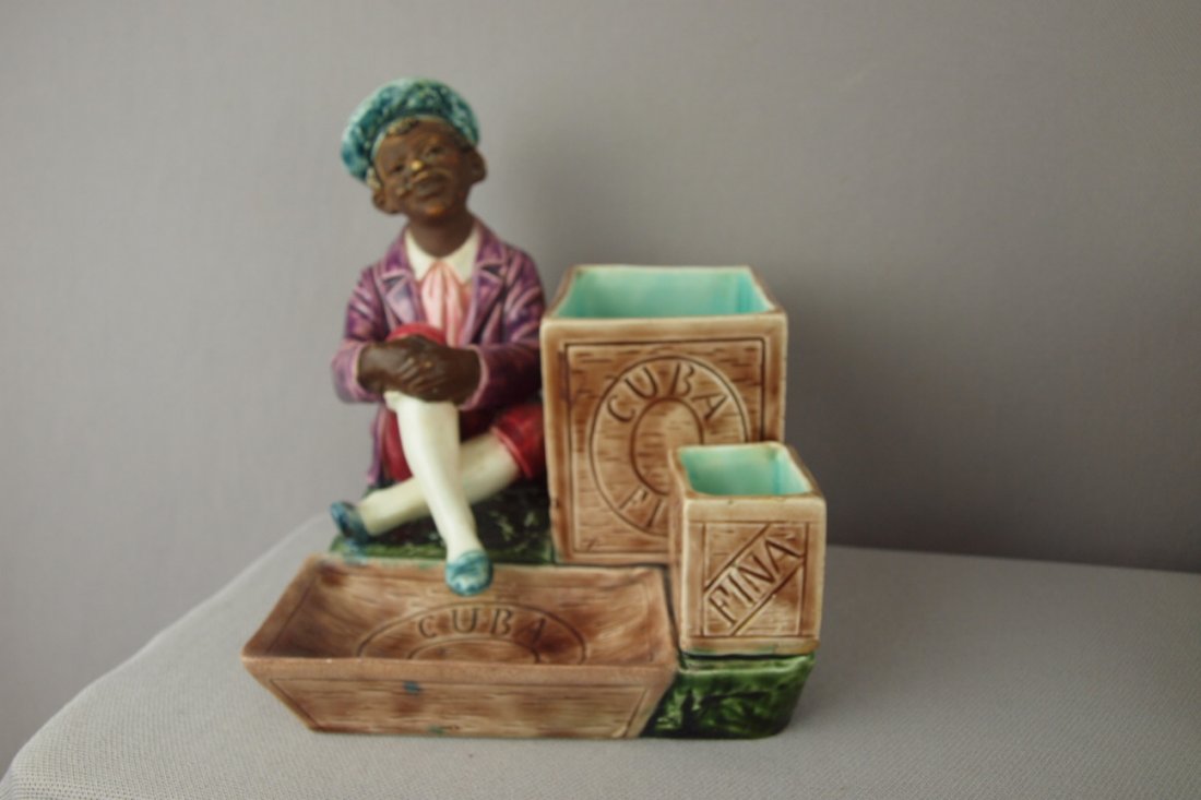 Continental Blackamoor match striker with man sea: Continental Blackamoor match striker with man seated with crates advertising "Cuba Fina" , professional repair to rim, 6 1/2"
