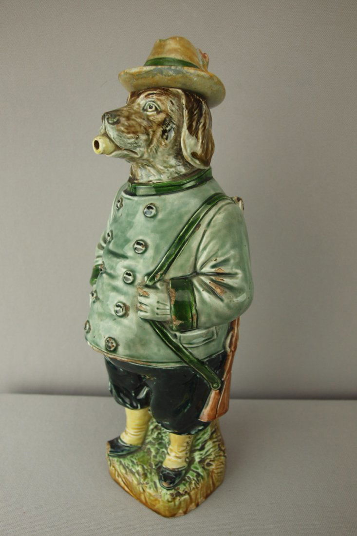 Continental figural bottle of hunting dog with gu: Continental figural bottle of hunting dog with gun, 12 1/2", repair to hat, chips to dog